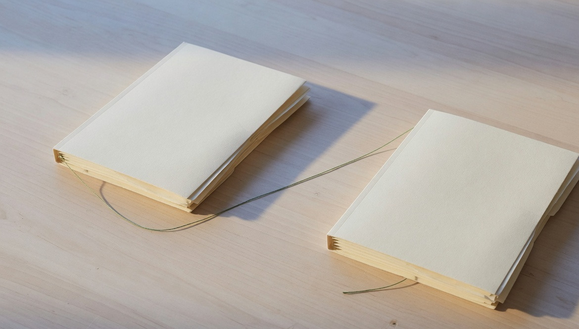 Two document stacks joined by a green thread.
